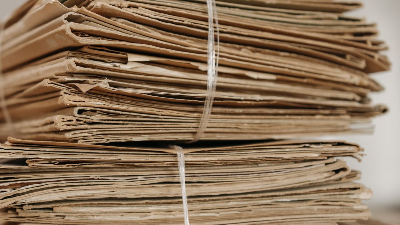 Two tied bundles of brown paper folders stacked one on top of the other, suggesting the two layers of house and master bills of lading